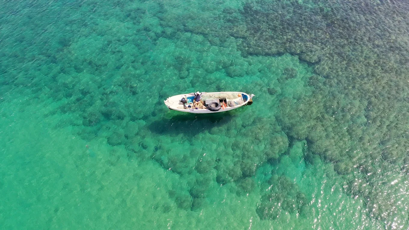Fishing boat on emerald green water at Jiyeh